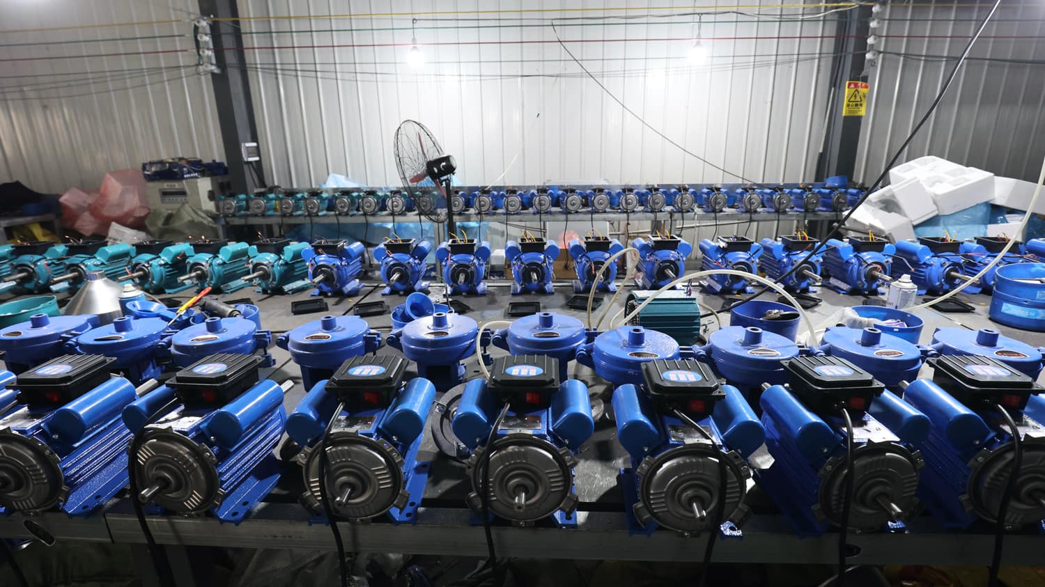 MOTOR LINE — drives staged for assembly and bench testing before they ship inside grinding and threshing machines.